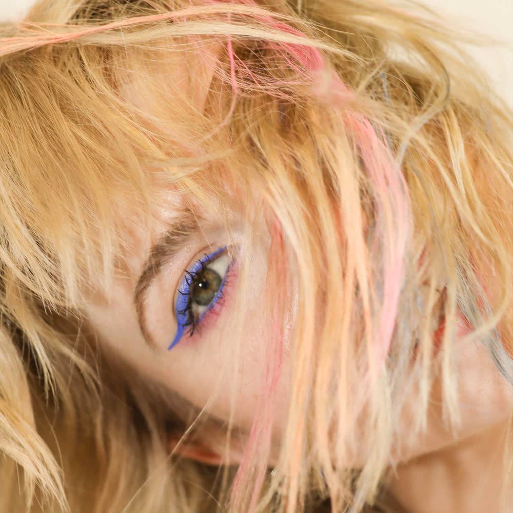 Hayley Williams with platinum blonde hair and pink color pops, on tour with Paramore