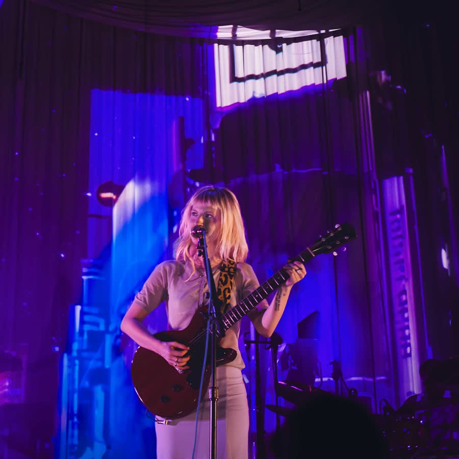 Hayley Williams performing solo on a dark stage