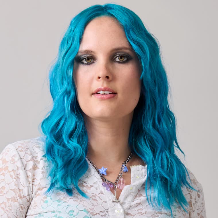 A model with wavy teal hair, wearing Narwhal