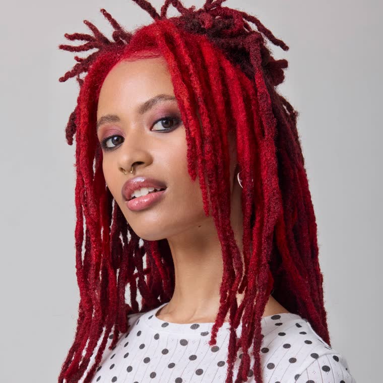 A model with deep red locs, wearing Rock Lobster